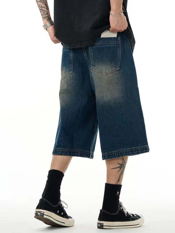 Men's blue cropped pants in street style, featuring a relaxed fit and denim fabric, suitable for casual wear.