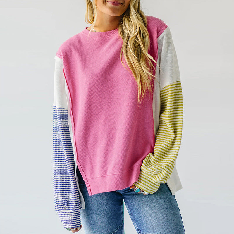 Pink and yellow striped sweatshirt displayed on a hanger against a neutral background.