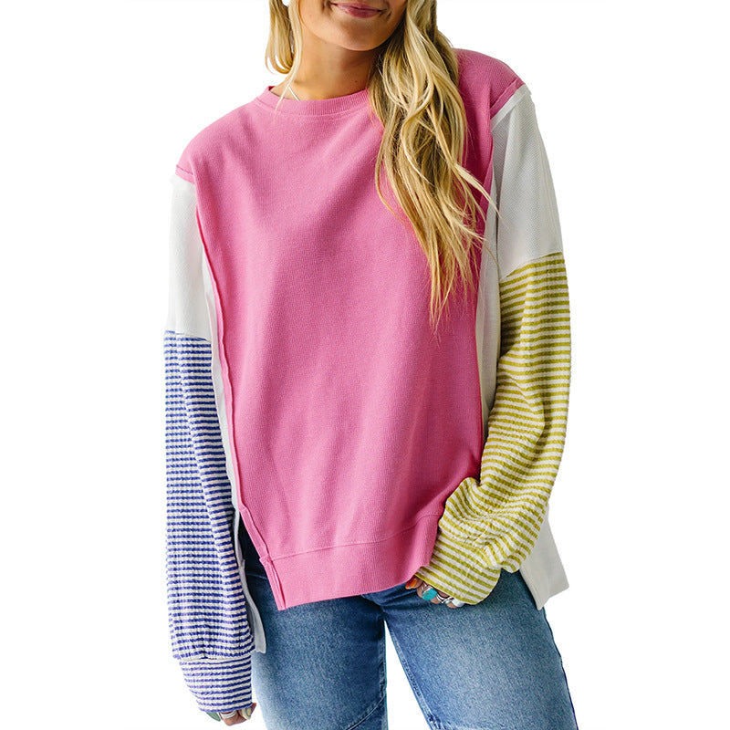 Pink and yellow striped sweatshirt displayed on a hanger against a neutral background.
