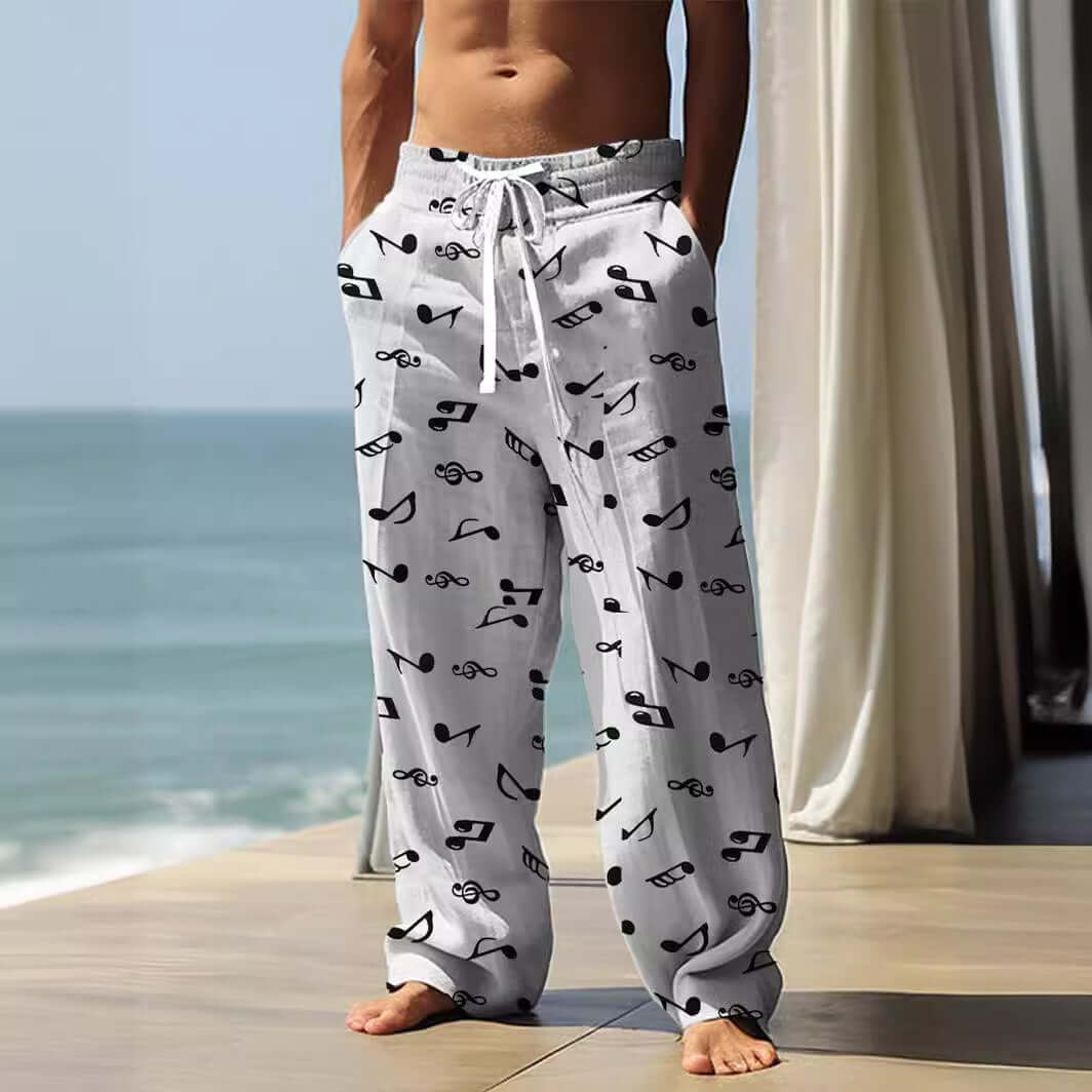 Man wearing baggy straight-leg pants with 3D vintage print on a beach, showcasing a relaxed style.