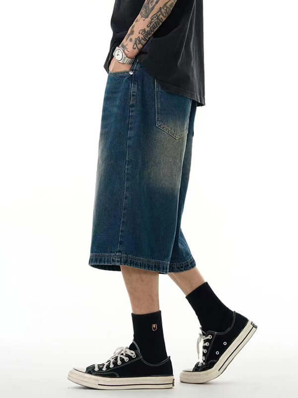 Men's casual cropped pants in blue denim, styled with sneakers and a relaxed fit, perfect for street fashion.